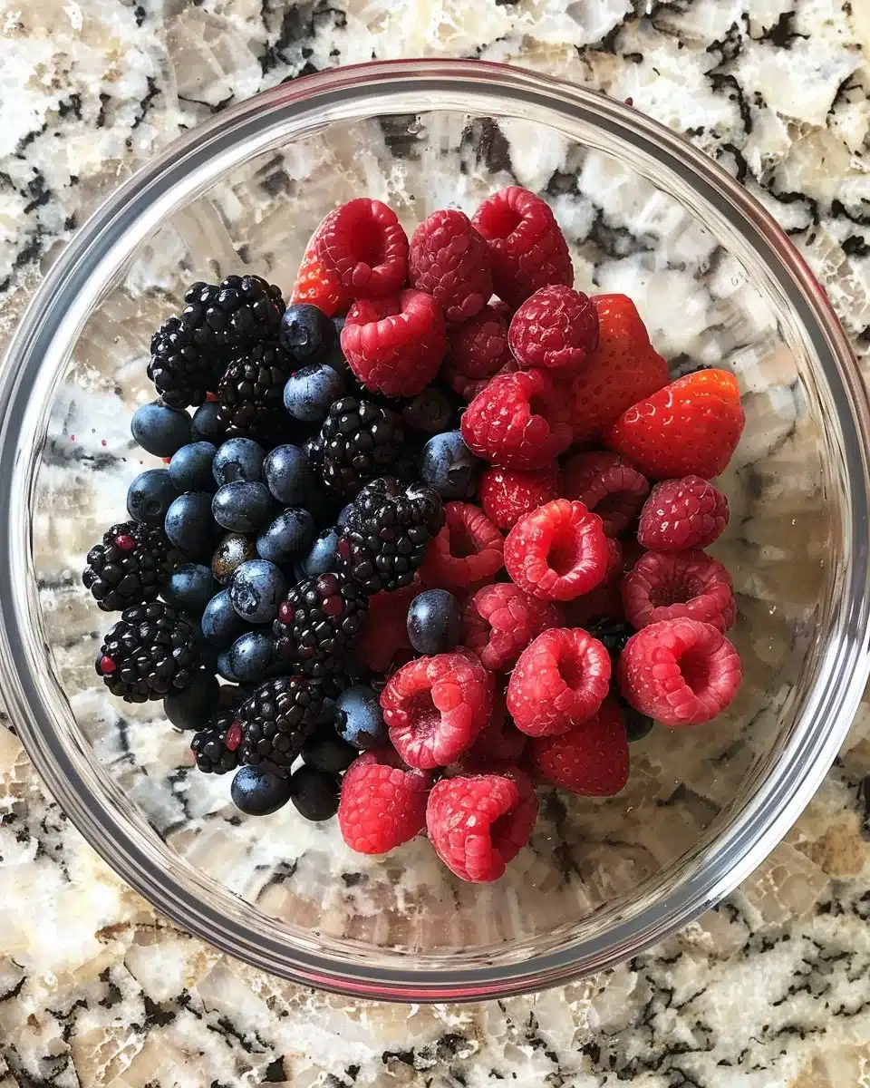 Mixed Berry Cobbler topped with golden, flaky crust and fresh berries.
