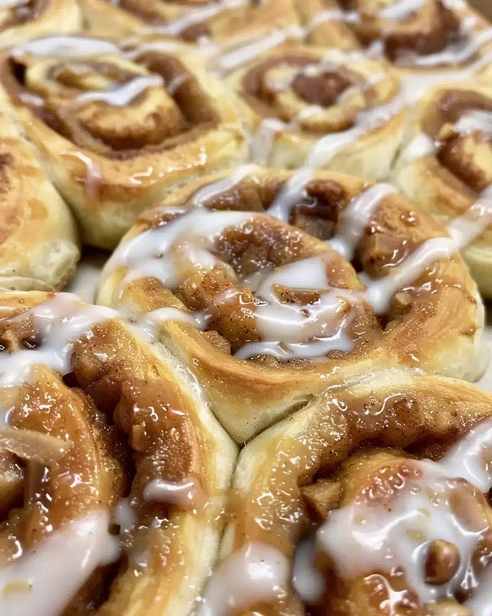 Apple Fritter Cinnamon Roll Bake showing a delicious golden-brown dessert with apple pieces.