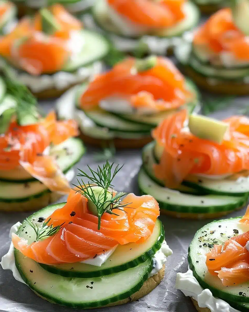 Cucumber bites with smoked salmon and dill cream cheese appetizer on a platter